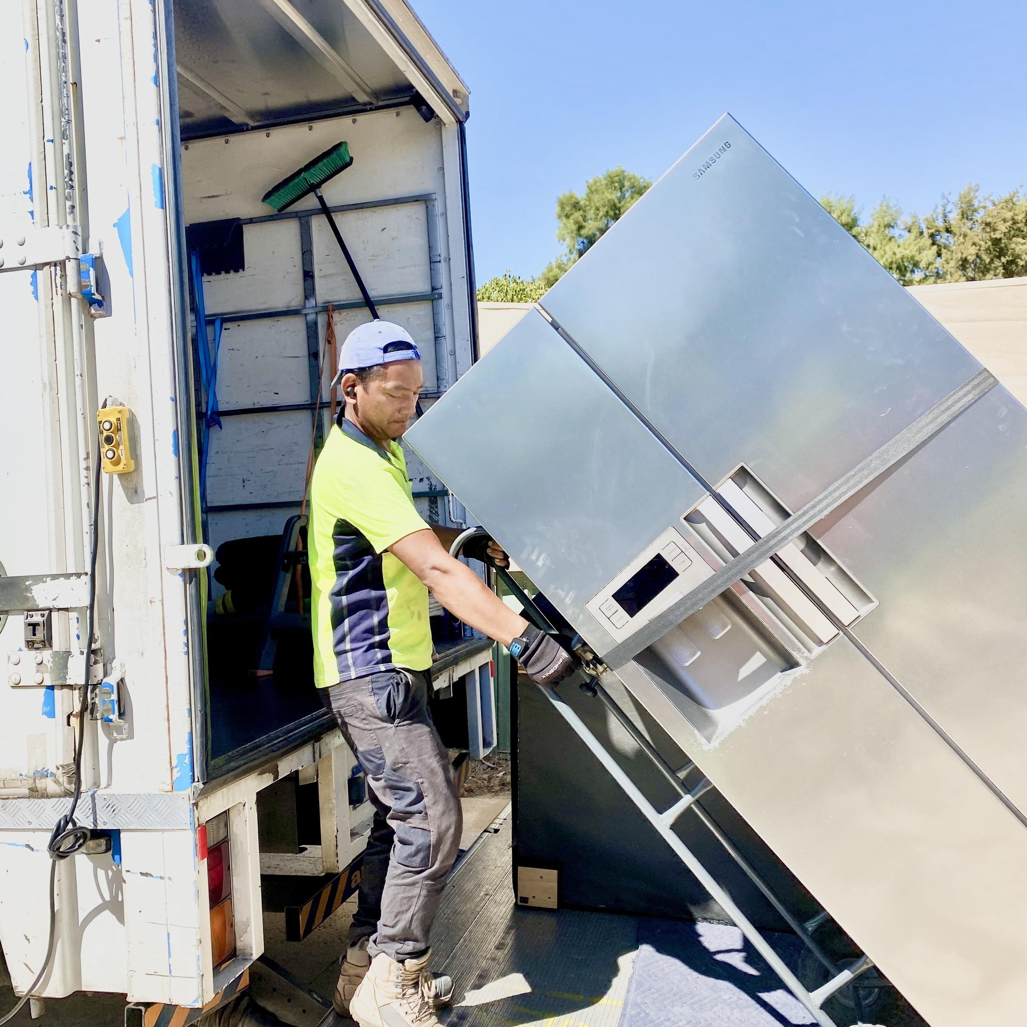 Man moving fridge into moving truck